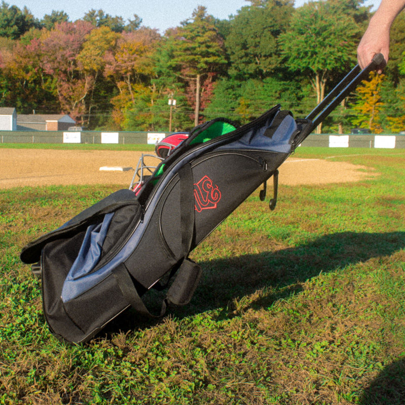 Someone wheeling the Rango Sports Clubhouse bag across a field with the retractable handle
