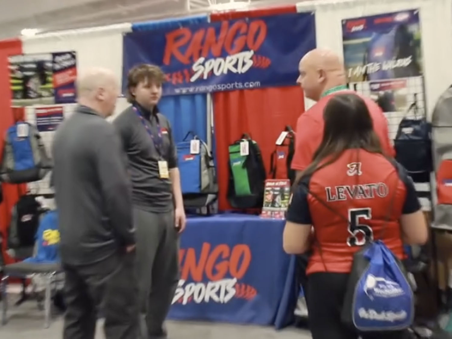 The Rango Sports team talking with attendees in front of their booth at the 2024 World Coach Event at Mohegan Sun 